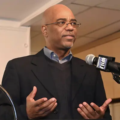 A bust photo of Poet Laureate Scott Pleasants speaking at a microphone. 